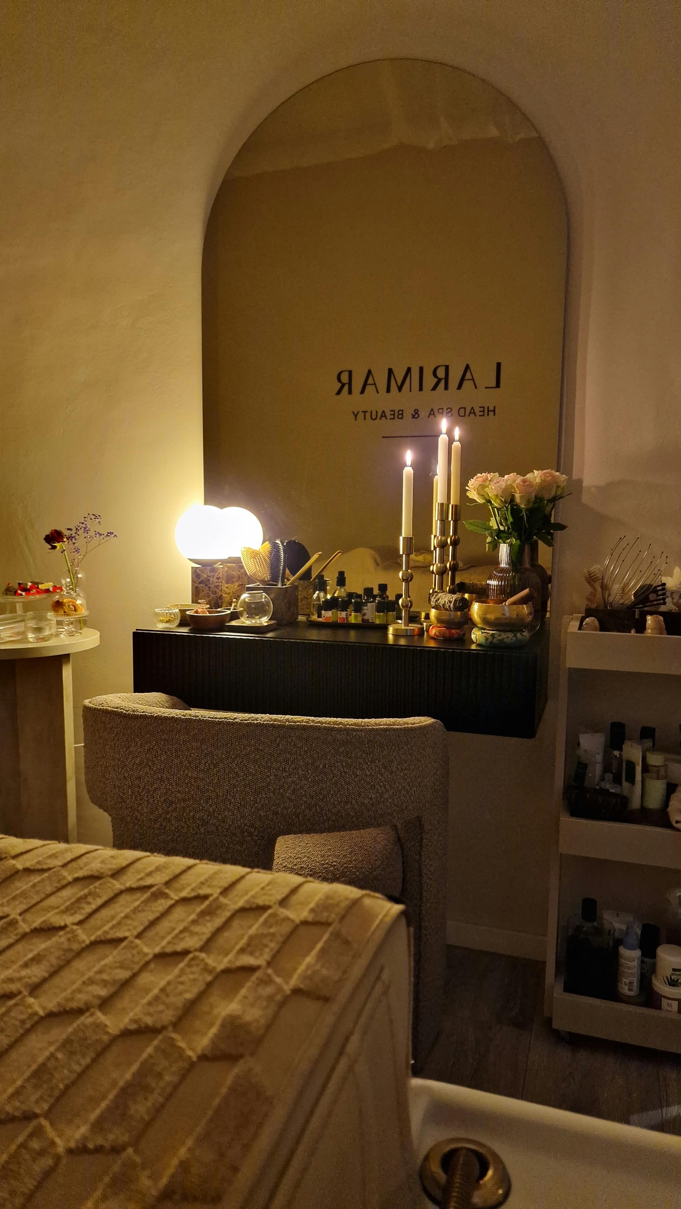 Behandlungszimmer mit gewölbtem Spiegel, Kerzen und Sessel